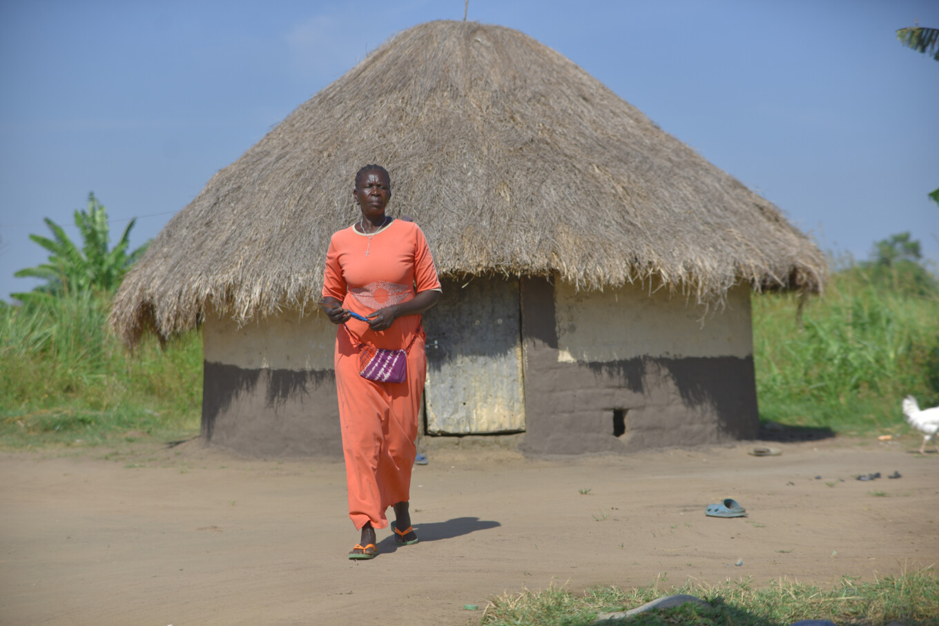 kvinna framför hus i Uganda