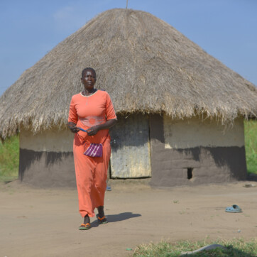 kvinna framför hus i Uganda