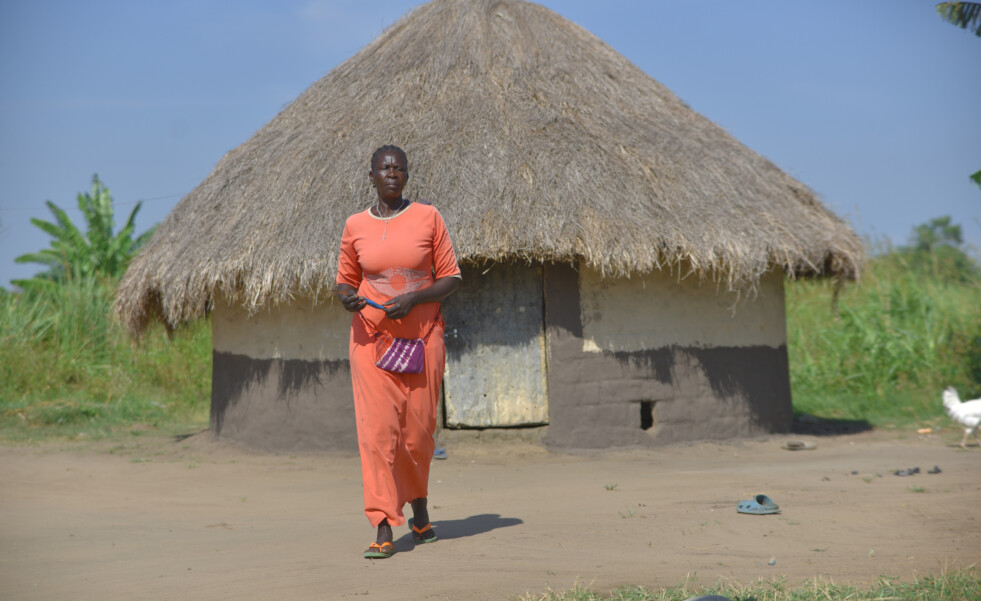 kvinna framför hus i Uganda