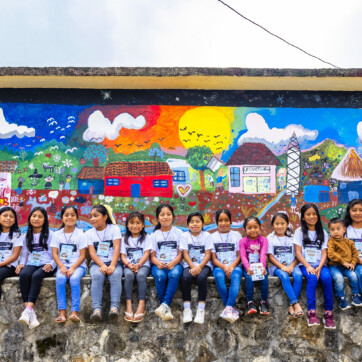 Flickor sitter tillsammans på en mur i Mexiko