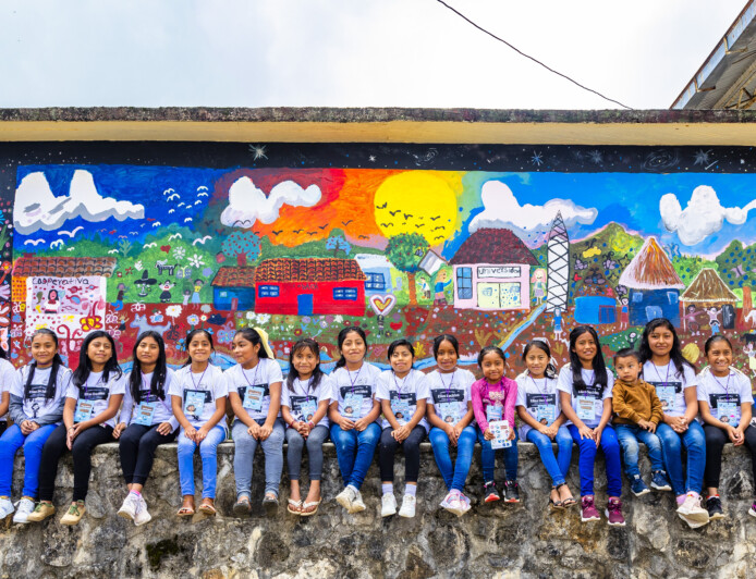 Flickor sitter tillsammans på en mur i Mexiko