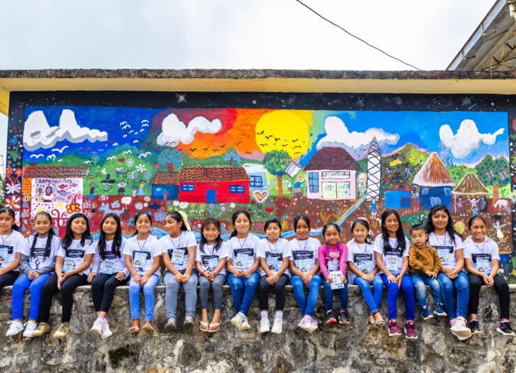 Flickor sitter tillsammans på en mur i Mexiko